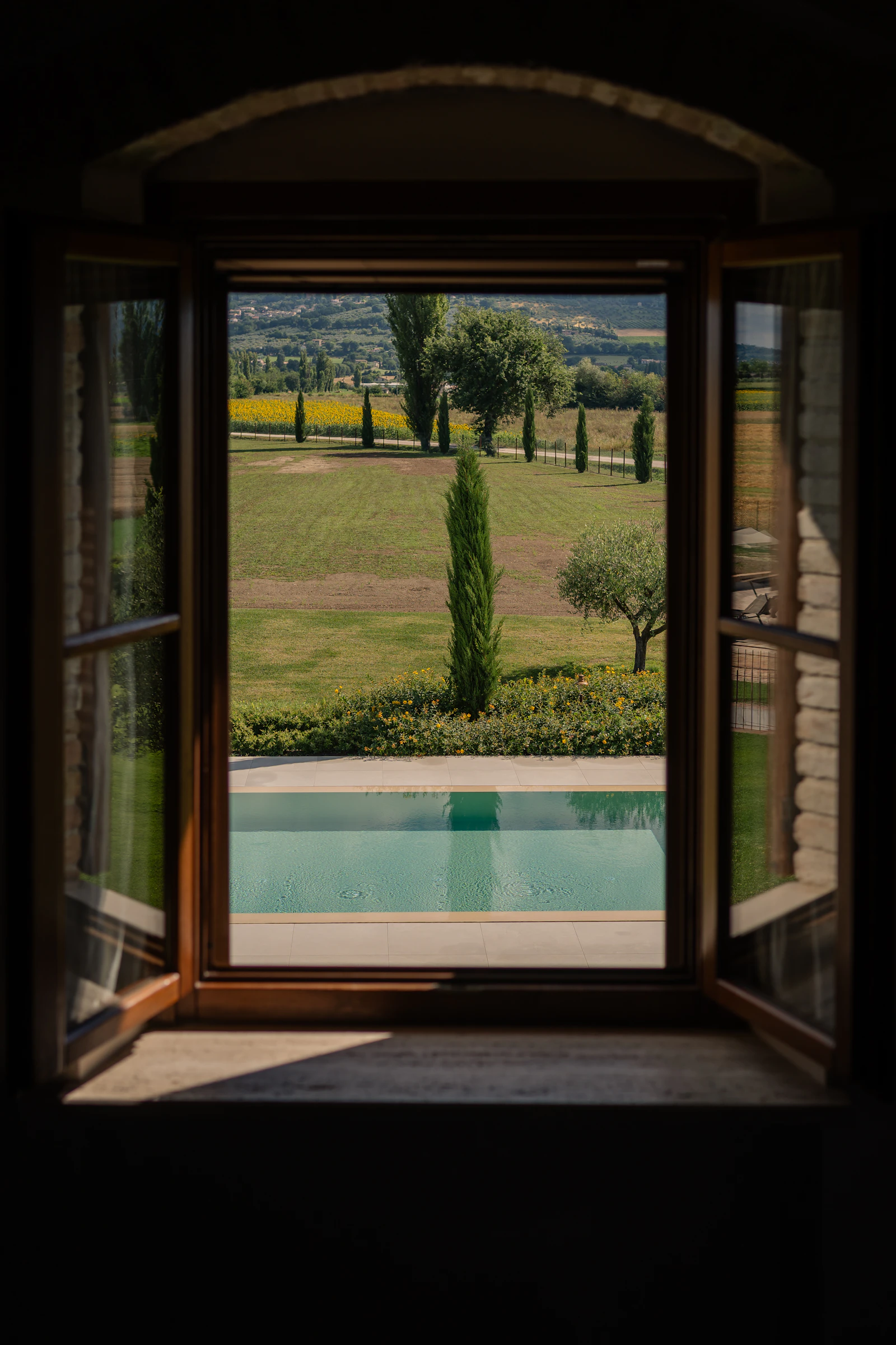 Dalla finestra, la piscina e i campi del podere